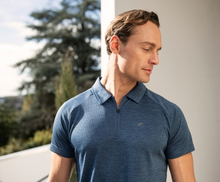 Mann in blaumeliertem Zip-Poloshirt der Makre JOY sportswear.