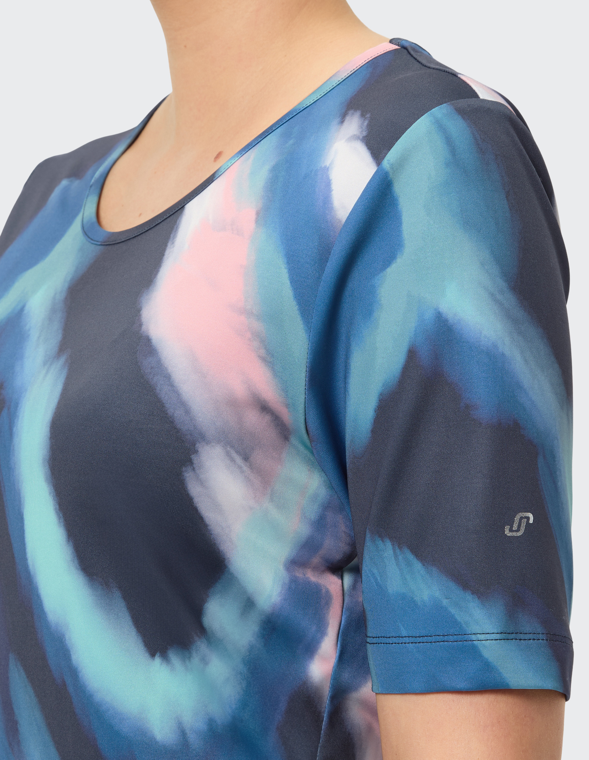 Nahaufnahme eines T-Shirts in dunkelblau mit abstraktem Aquarelldesign in Blau-, Rosa- und Weißtönen, Rundhalsausschnitt.