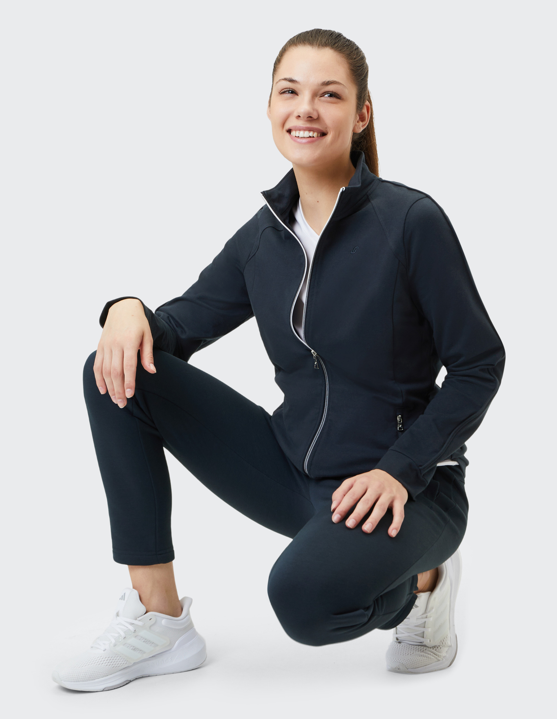 Dunkelblaue Jacke mit Stehkragen, Reißverschluss und zwei seitlichen Taschen, aus leichtem Stoff, schlichtes und modernes Design.