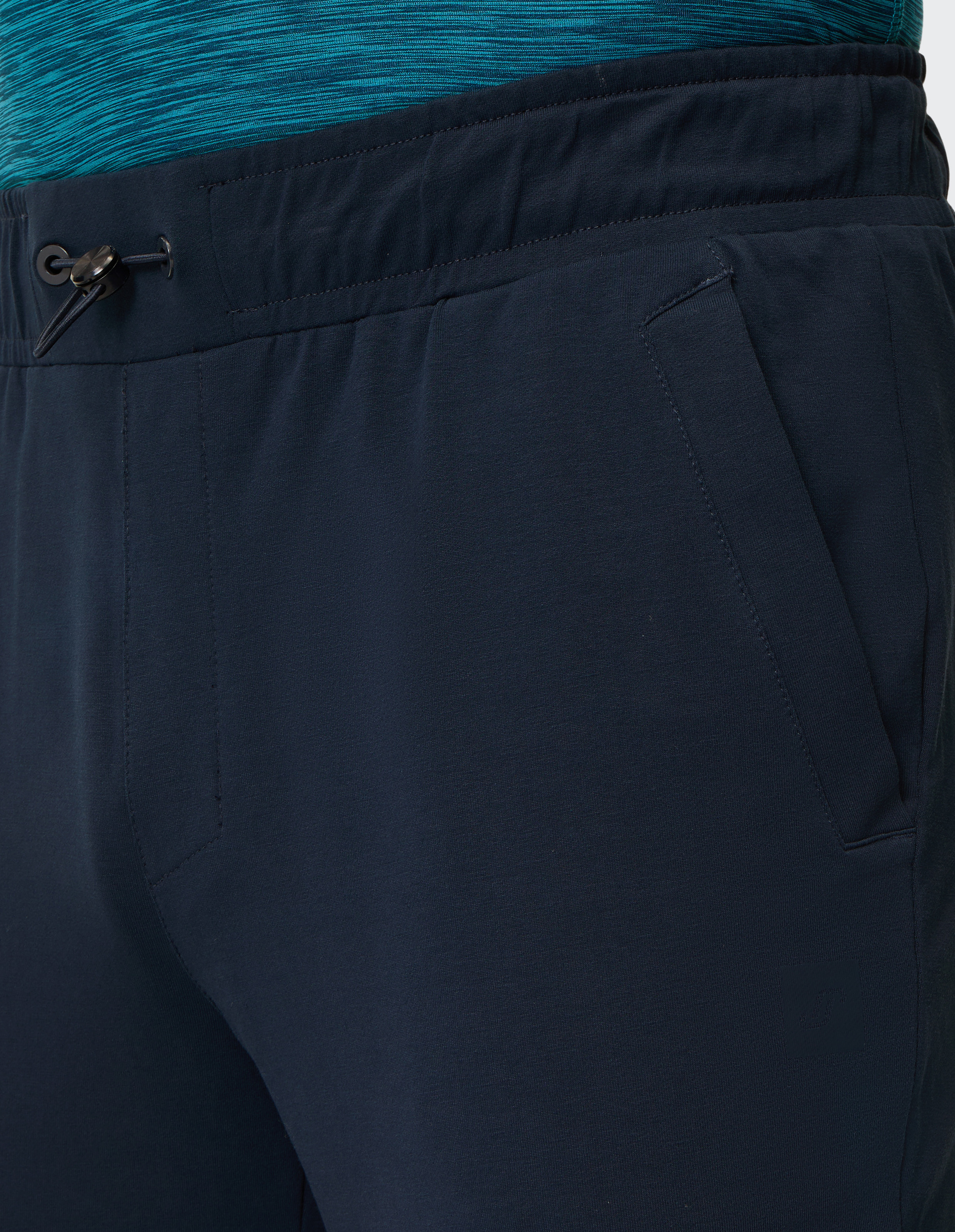 Dunkelblaue Jogginghose mit elastischem Bund und Kordelzug, daneben eine türkis-gemusterte Sportoberteilkante sichtbar.