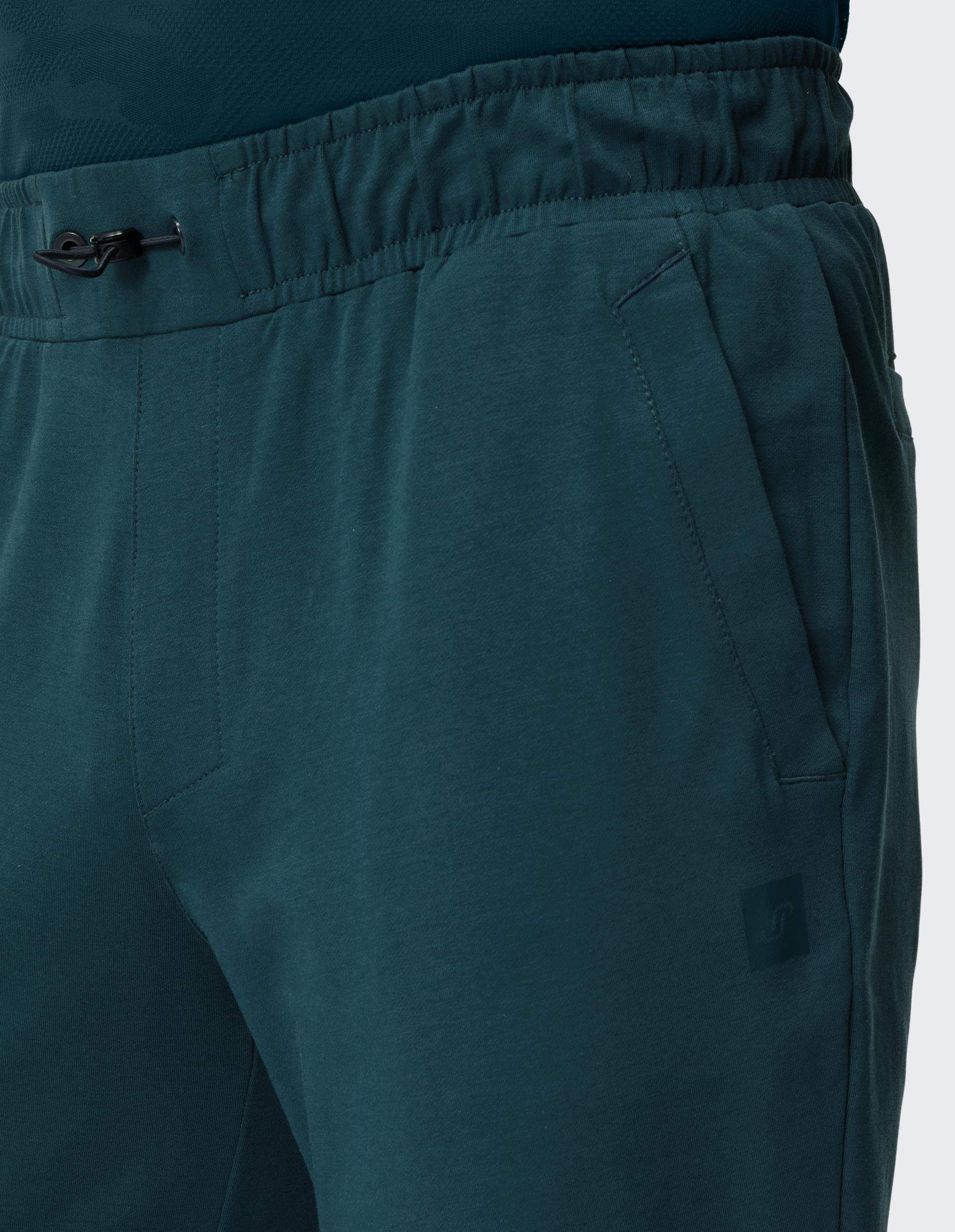 Dunkelgrüne Jogginghose mit elastischem Bund, Kordelzug, seitlichen Taschen und schmal zulaufendem Bein.