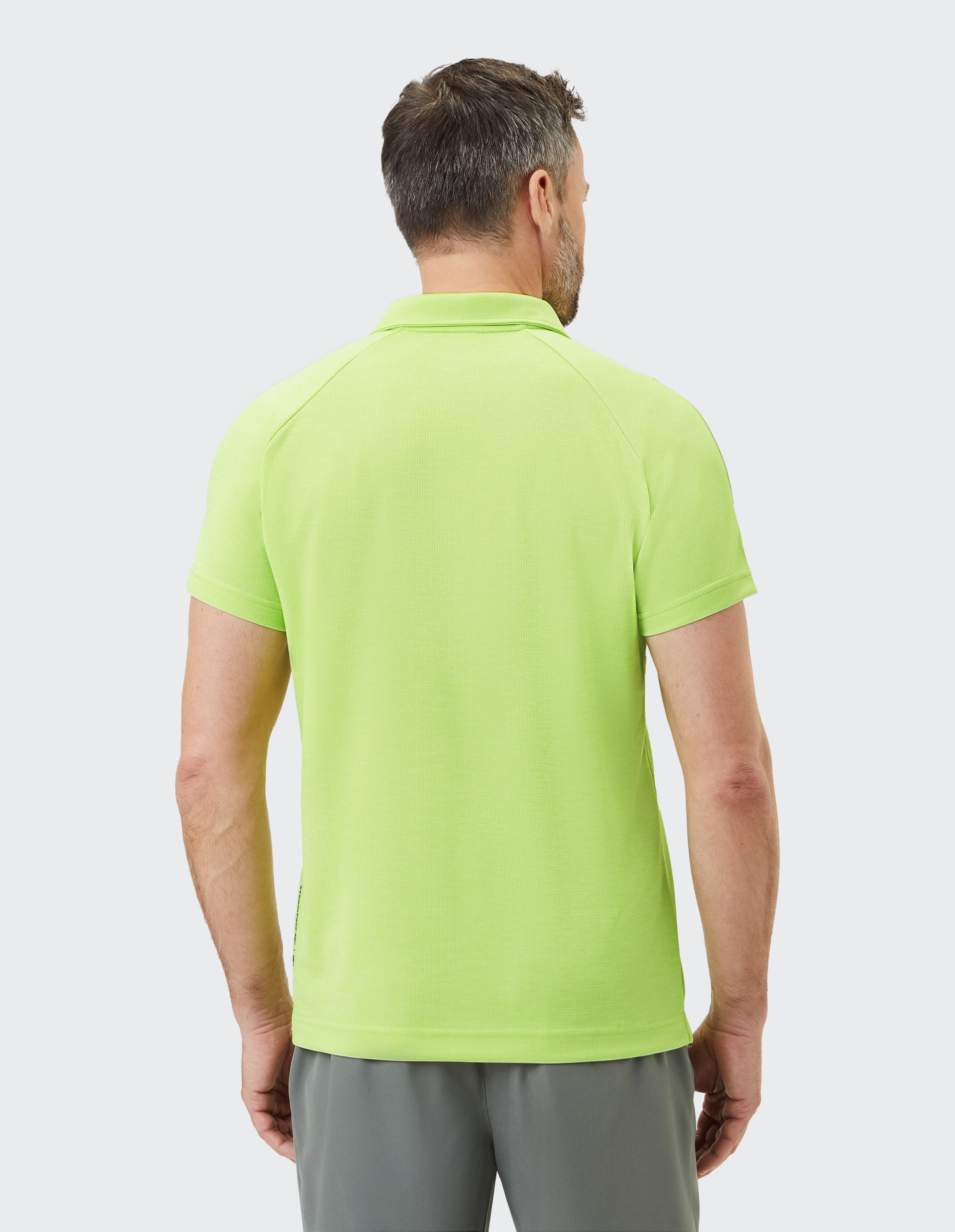 Limettengrünes Polo-Shirt mit kurzem Reißverschluss am Kragen, kurzem Arm und dezentem Logo auf der Brust.