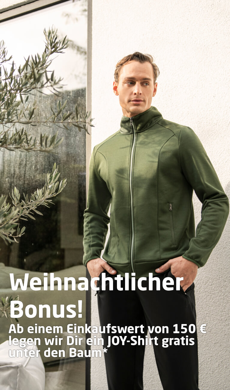Grüne Herren-Fleecejacke mit durchgehendem Reißverschluss, getragen von einem Mann vor heller Hauswand neben Olivenbaum im Sonnenlich