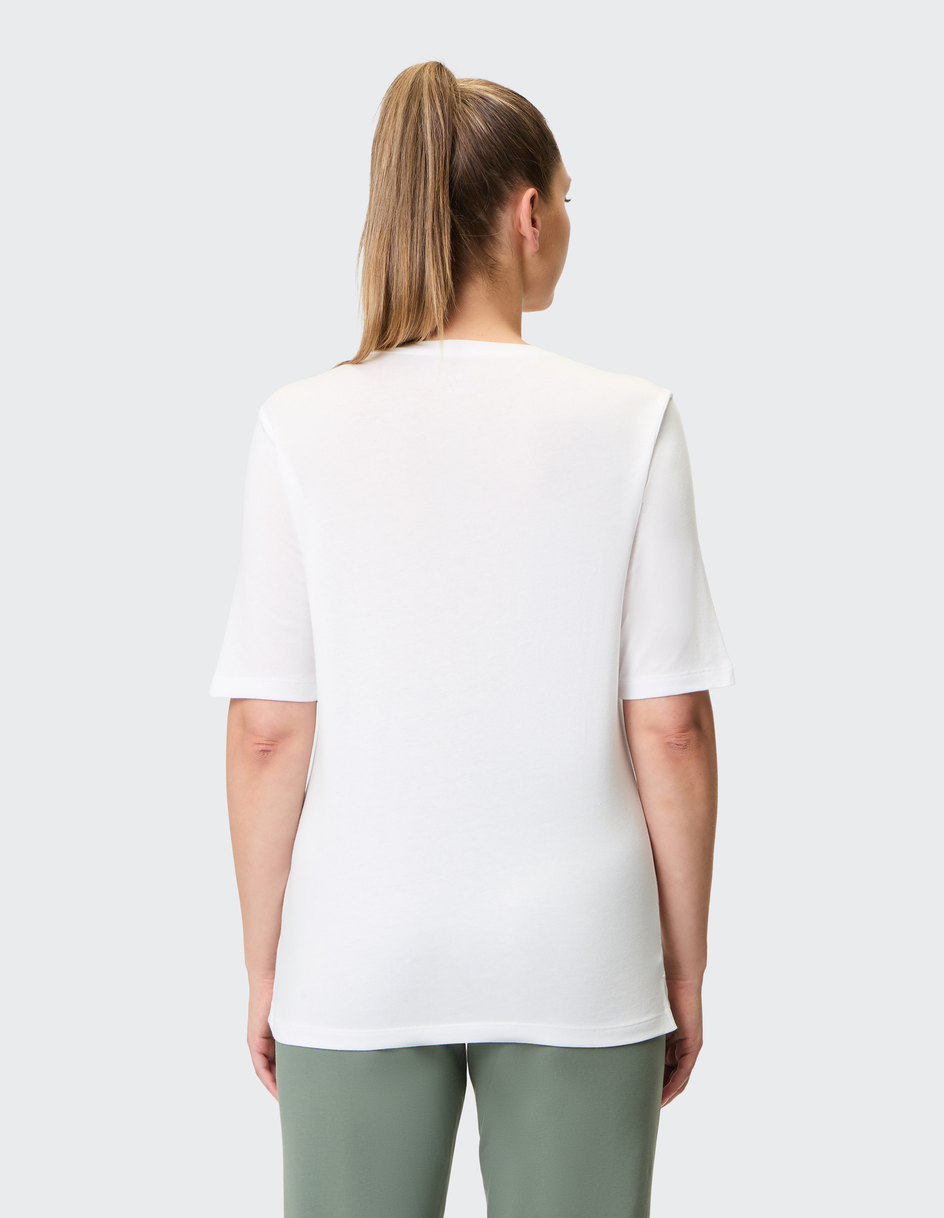 Weißes T-Shirt mit abstraktem Schmetterlingsdruck in Grün und Orange auf Schulter und Vorderseite, Halbärmel, Rundhalsausschnitt.