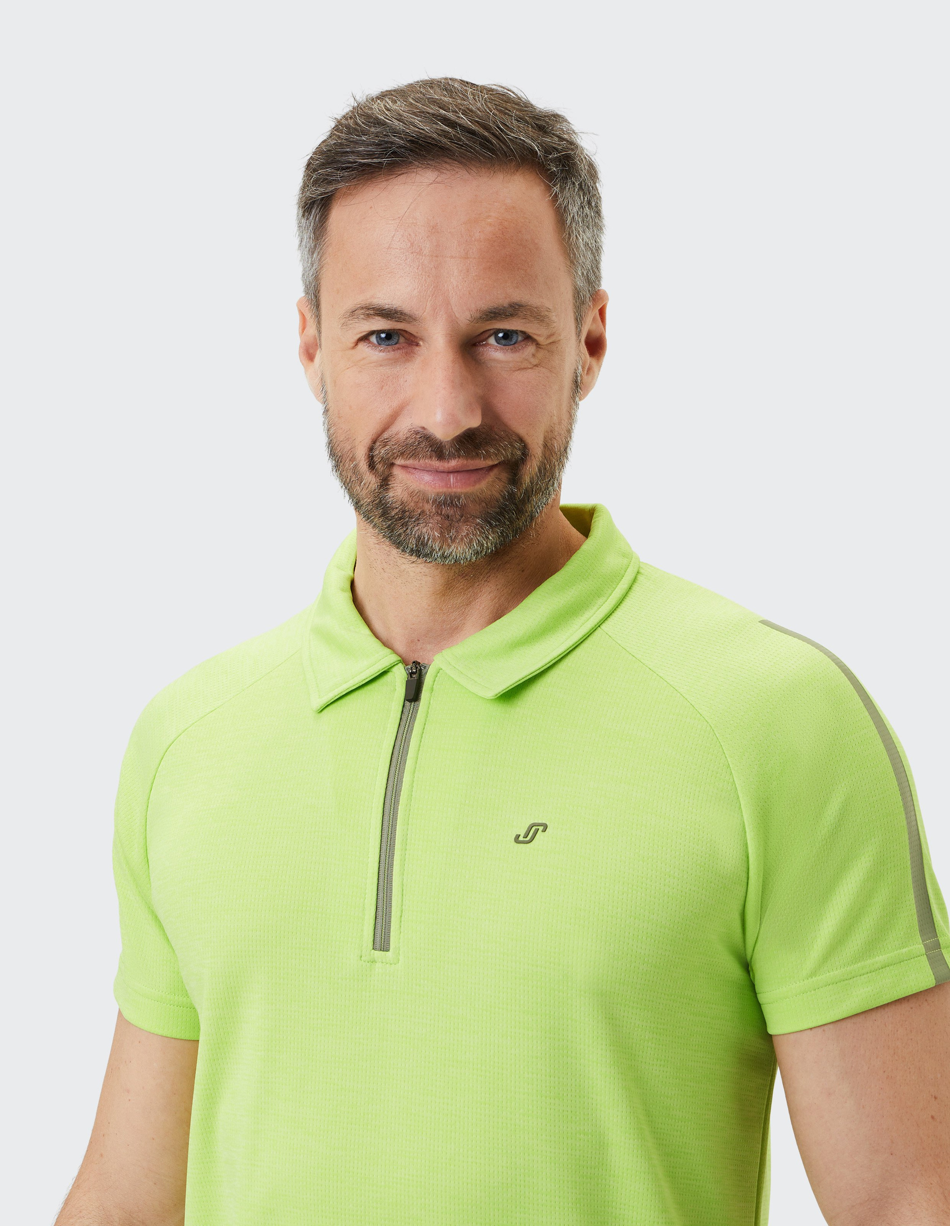 Limettengrünes Polo-Shirt mit kurzem Reißverschluss am Kragen, kurzem Arm und dezentem Logo auf der Brust.