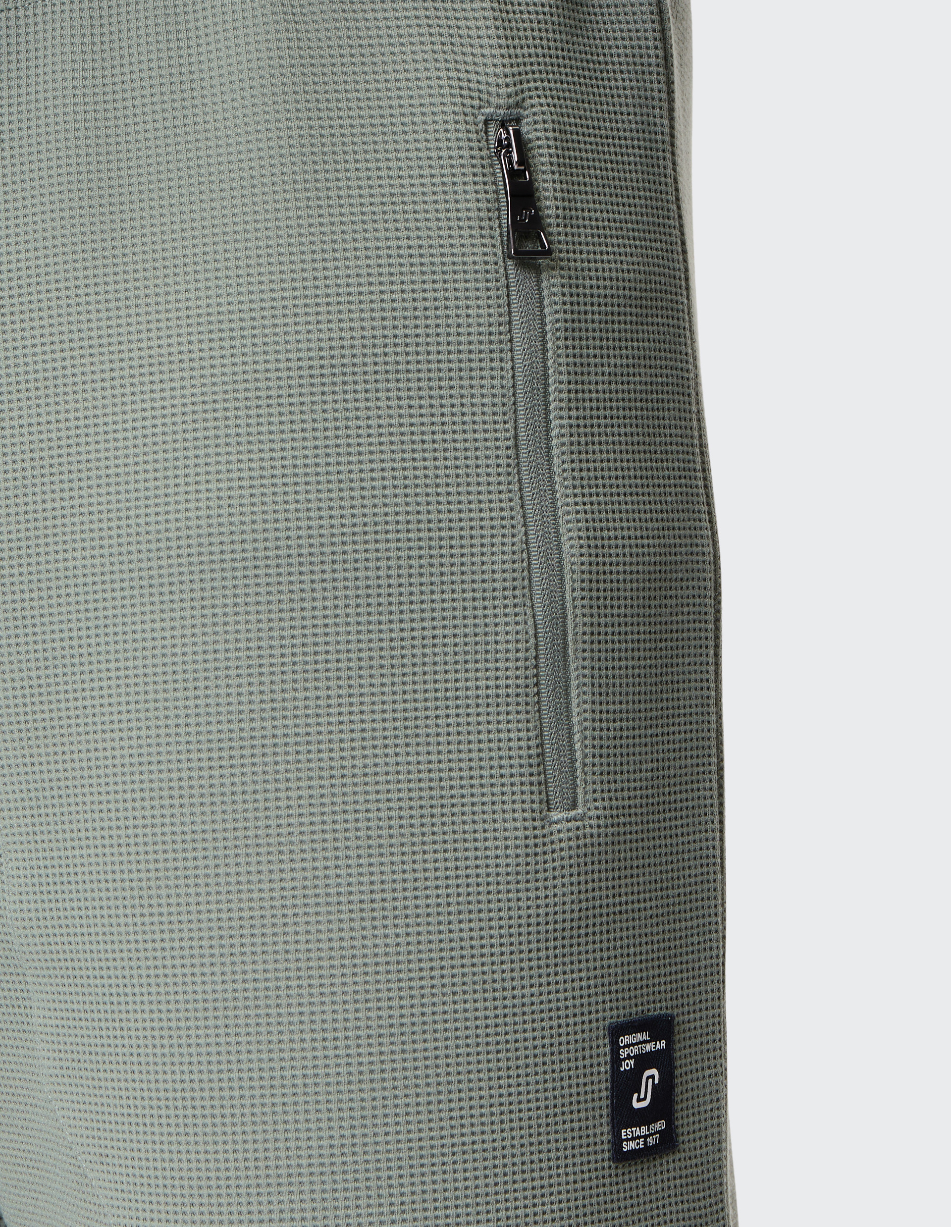 Hellgrüne Jogginghose mit Kordelzug und Seitentaschen, aus bequemen und leichten Stoff, ideal für Freizeit und Sport geeignet.