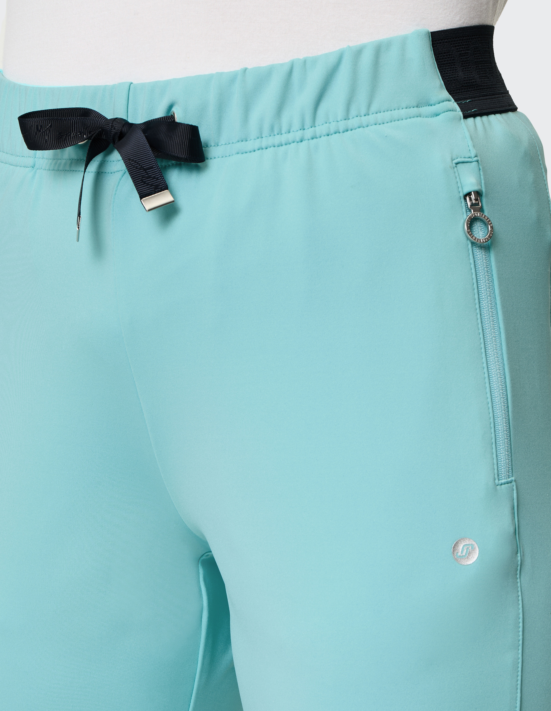 Türkise Sporthose mit schwarzem Band an elastischem Bund und silbernem Reißverschluss an der Seitentasche.