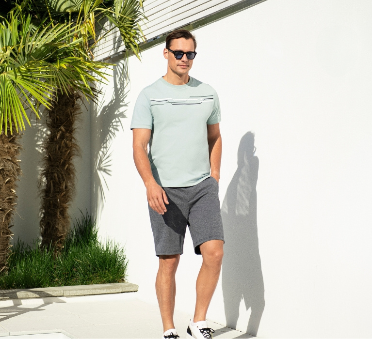 Mann in hellblauem Shirt und Sonnenbrille läuft.