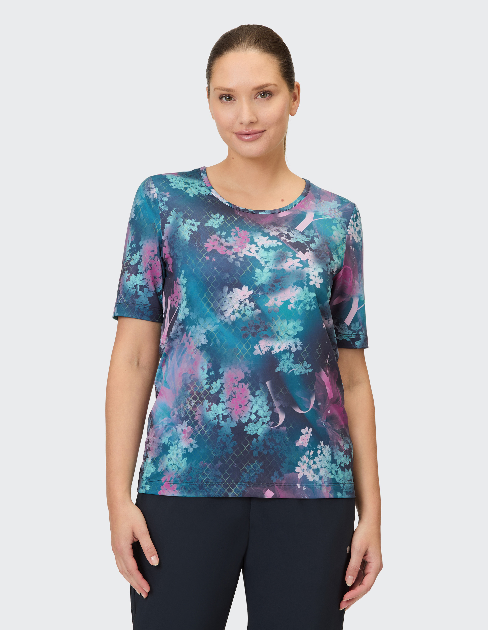 Blaues T-Shirt mit rundem Ausschnitt und Blumenmuster in Rosa- und Türkistönen mit filigranem Gittermuster.
