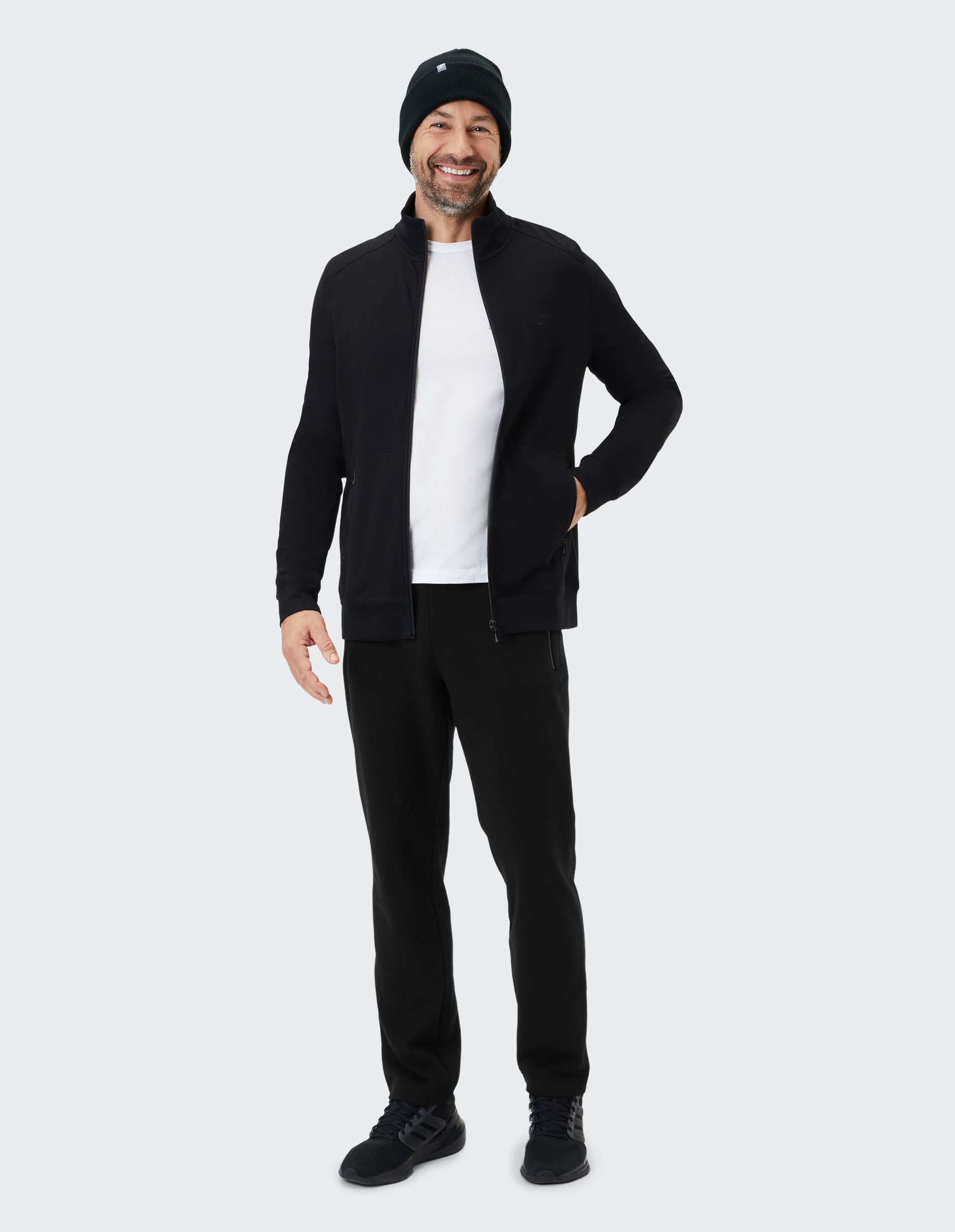 Schwarze Trainingsjacke mit hohem Kragen, durchgehendem Reißverschluss und zwei Reißverschlusstaschen, schlichtes Design.