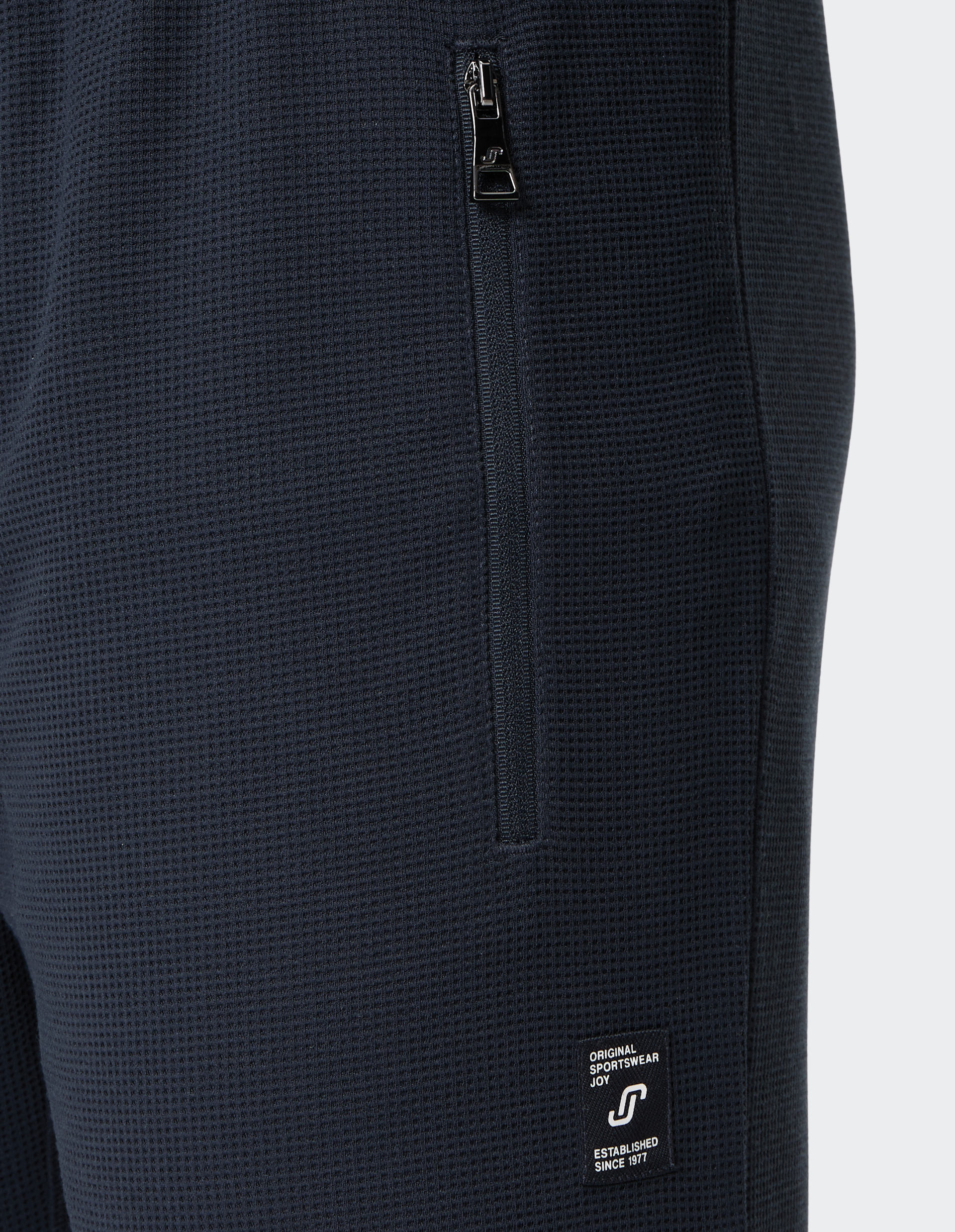 Dunkelblaue Jogginghose mit elastischem Bund, Kordelzug und Reißverschlusstaschen, aus weichem Stoff für Komfort.