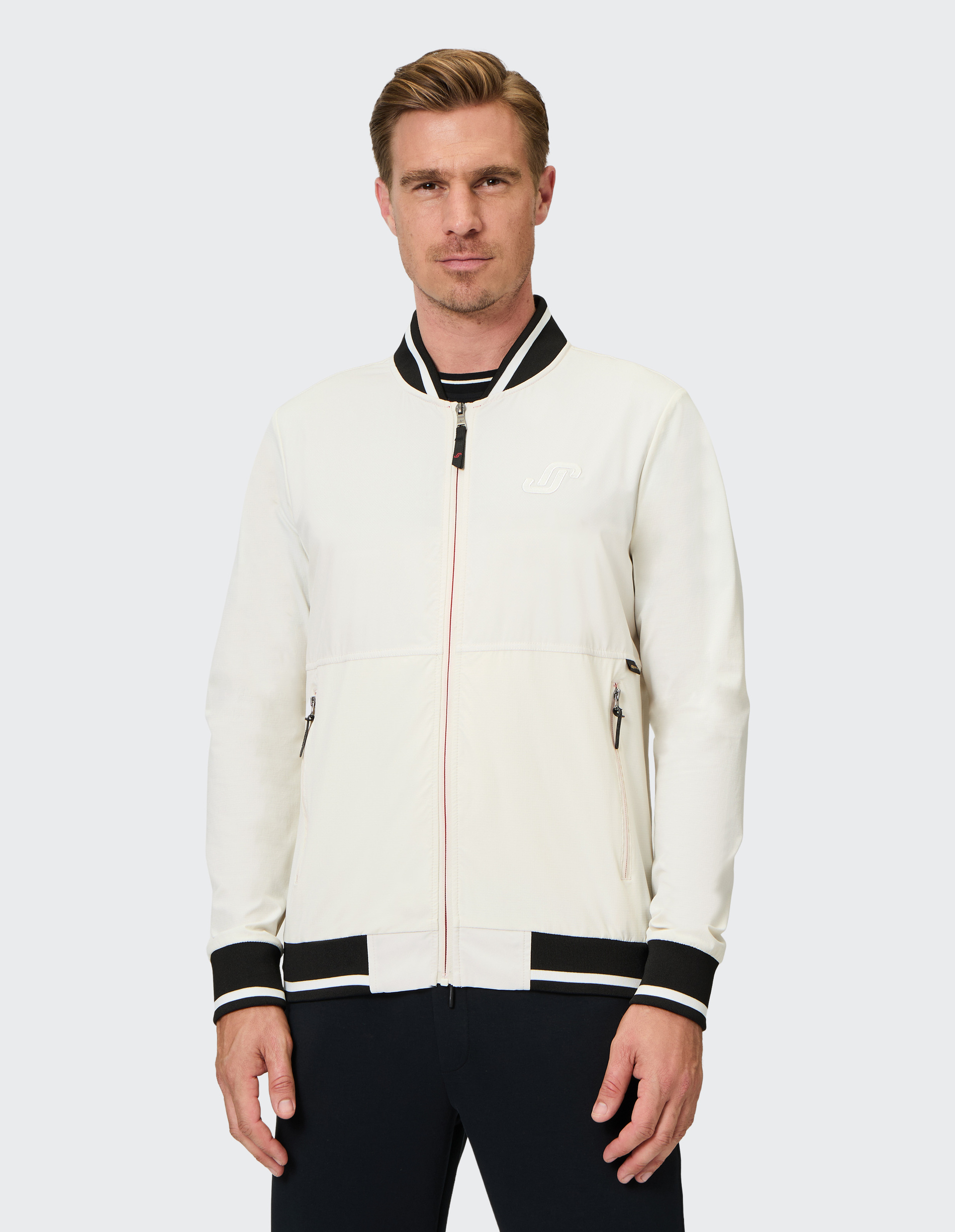 Weißer Blouson mit schwarzem Kragen und Bündchen, Reißverschluss, zwei Reißverschlusstaschen und dezentem Logo auf der Brust.