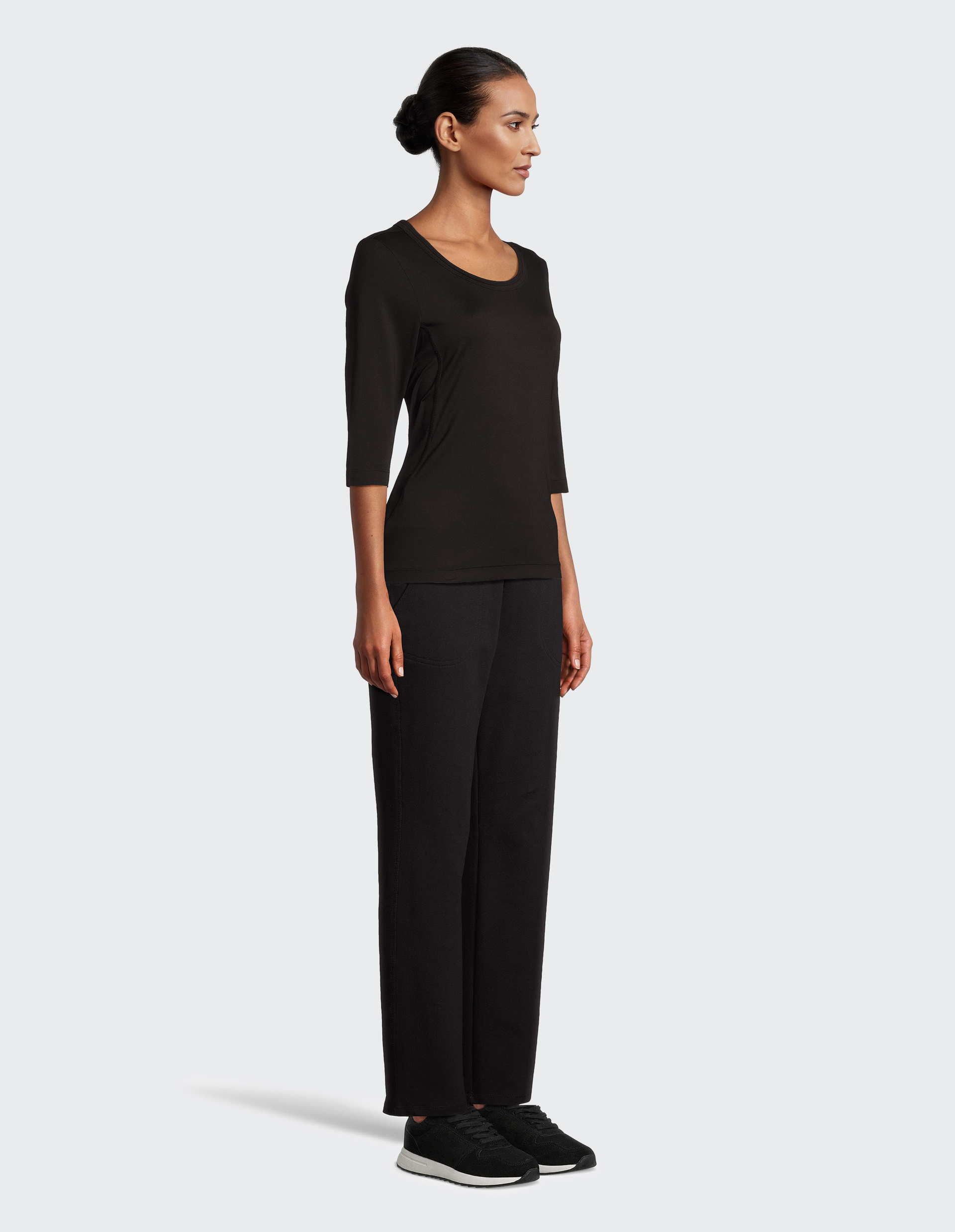 Schwarzes, dreiviertelärmeliges Damen-Top mit rundem Ausschnitt, schlichtem Design und kleiner Logostickerei am Saum.