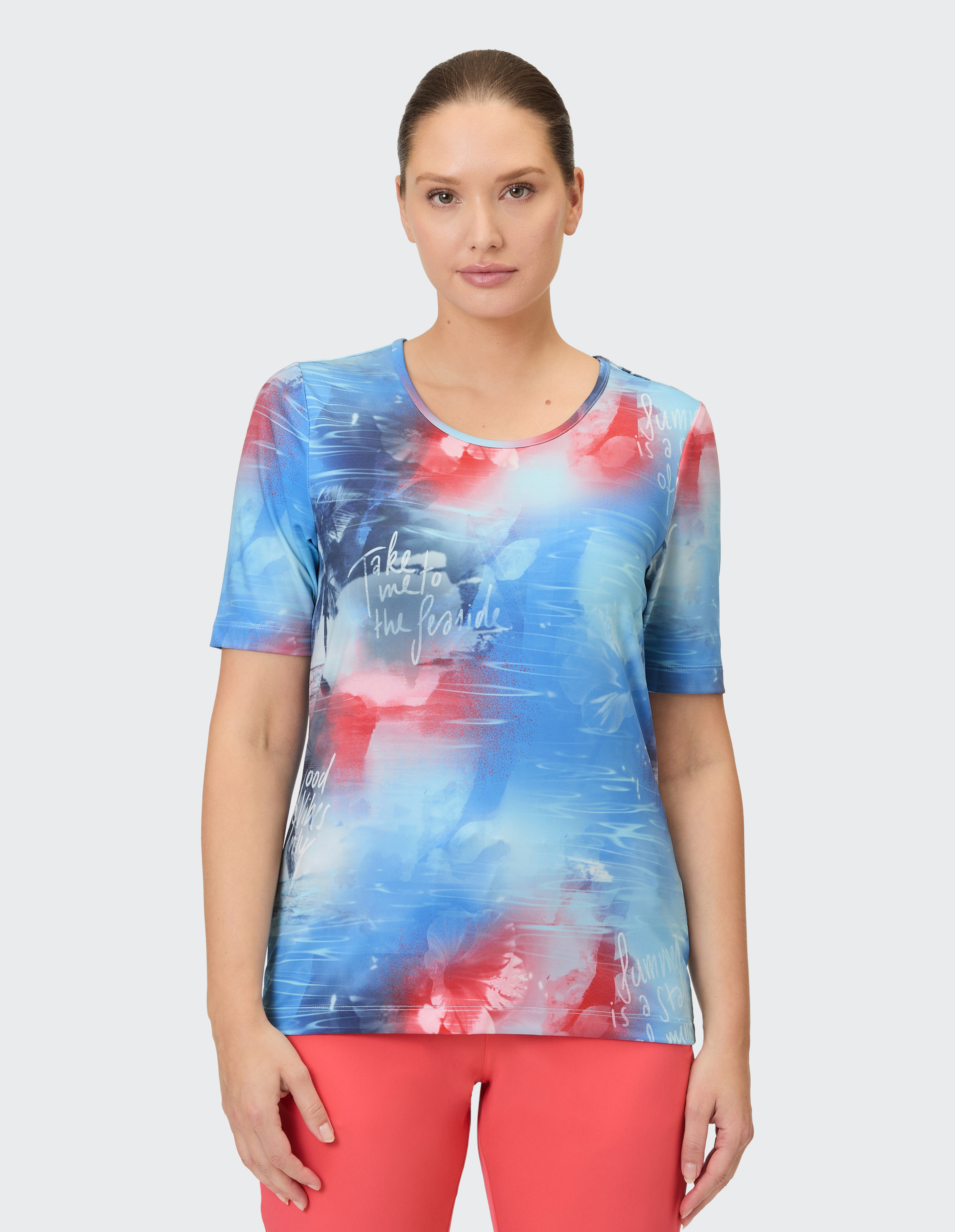 Ein blau-rotes T-Shirt mit abstraktem Muster, das an Wasser und Blumen erinnert.