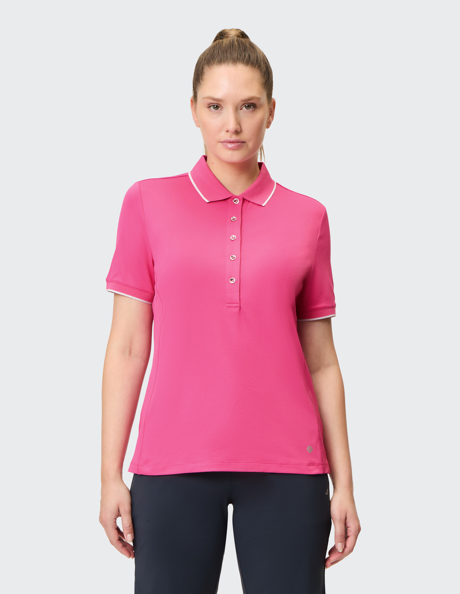 Ein leuchtend pinkes Polohemd mit weißen Details am Kragen und fünf Knöpfen, Kurzarm und geradem Schnitt.
