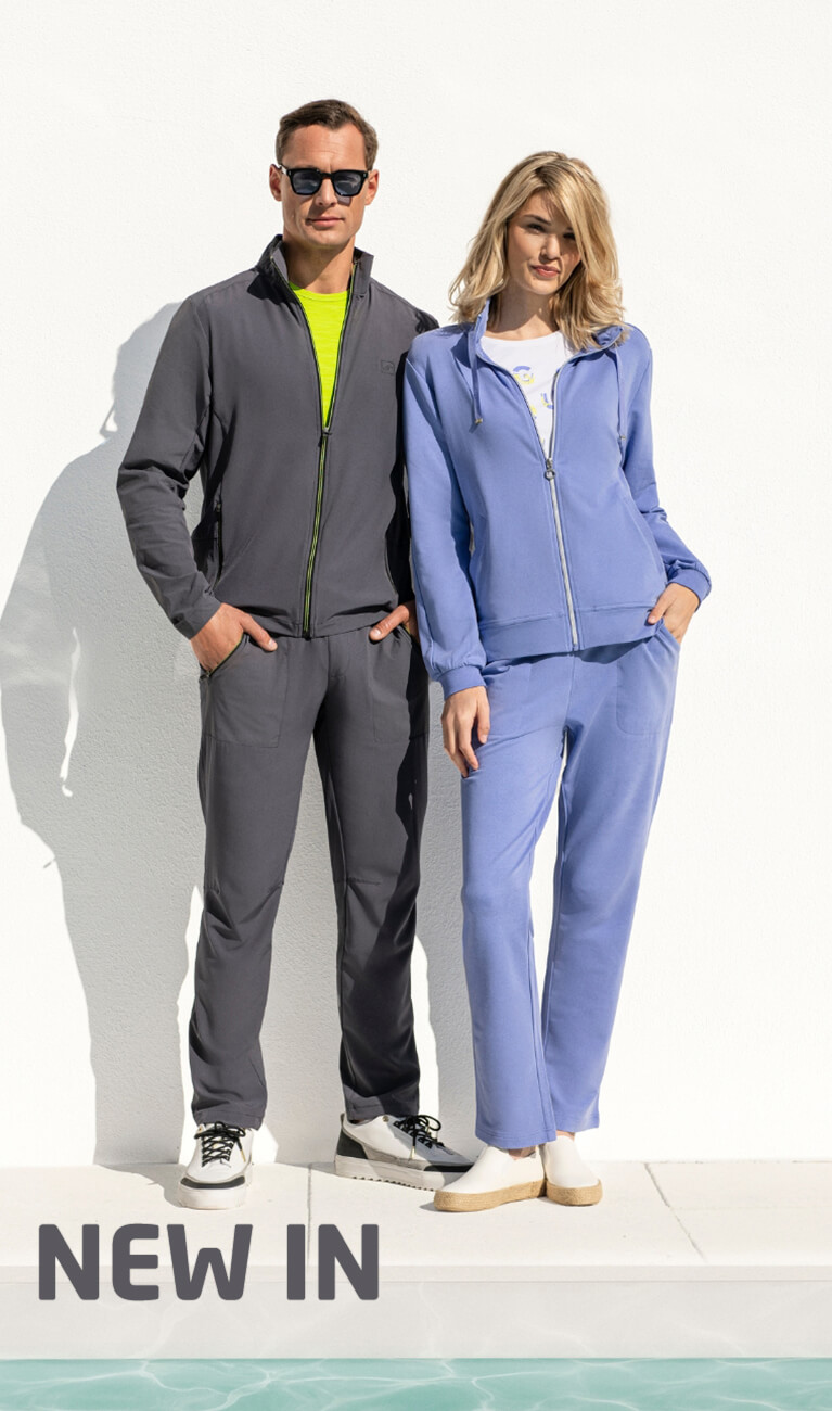 Mann in grauem Hoodie mit gelbem Akzent und Frau in hellem blauen Jogginganzug, stehend vor weißem Hintergrund mit Schatten, frische Sportmode 2026.