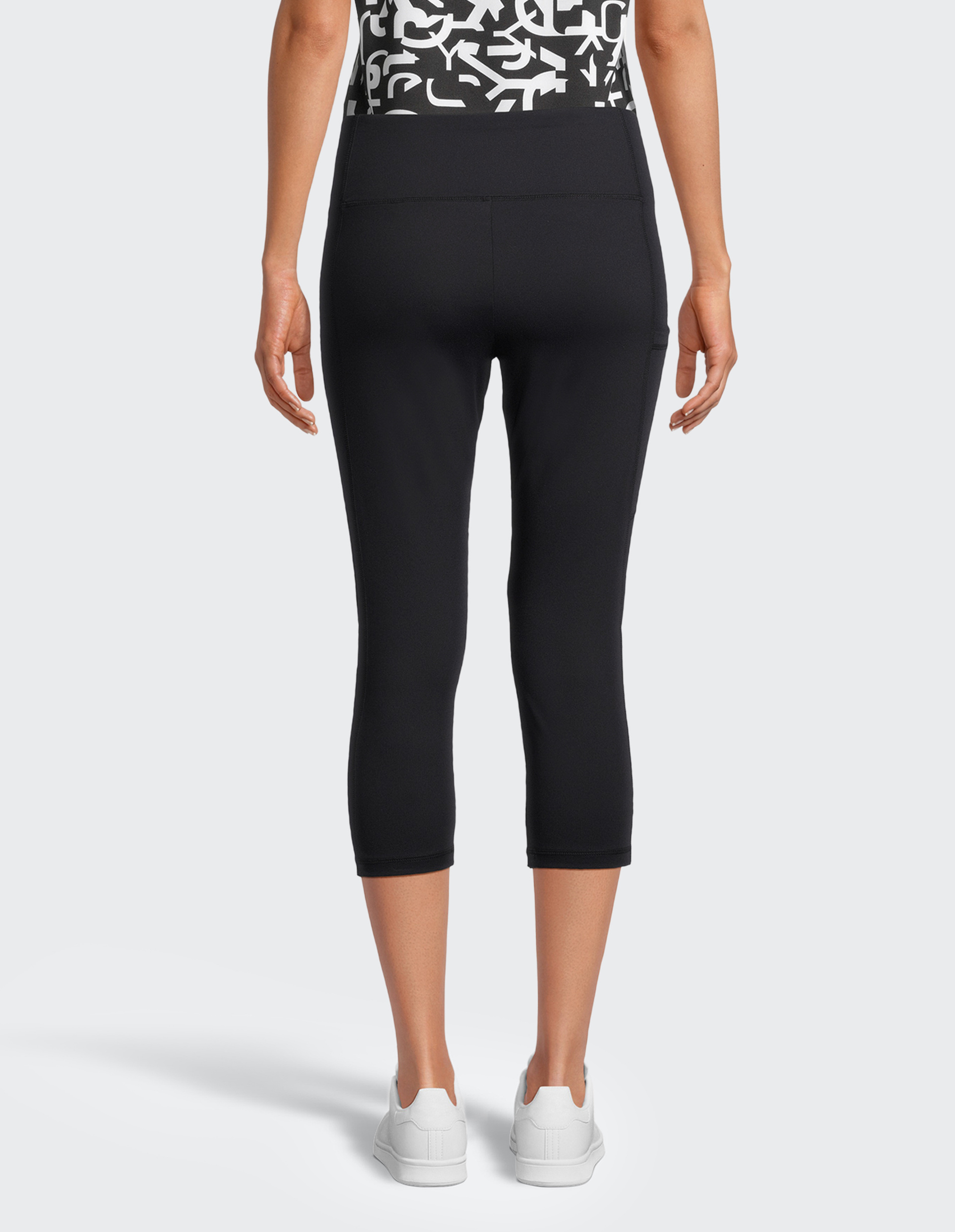 Dreiviertellange, schwarze Leggings mit hohem Bund, aus glattem, elastischem Material, ohne sichtbare Logos oder Muster.