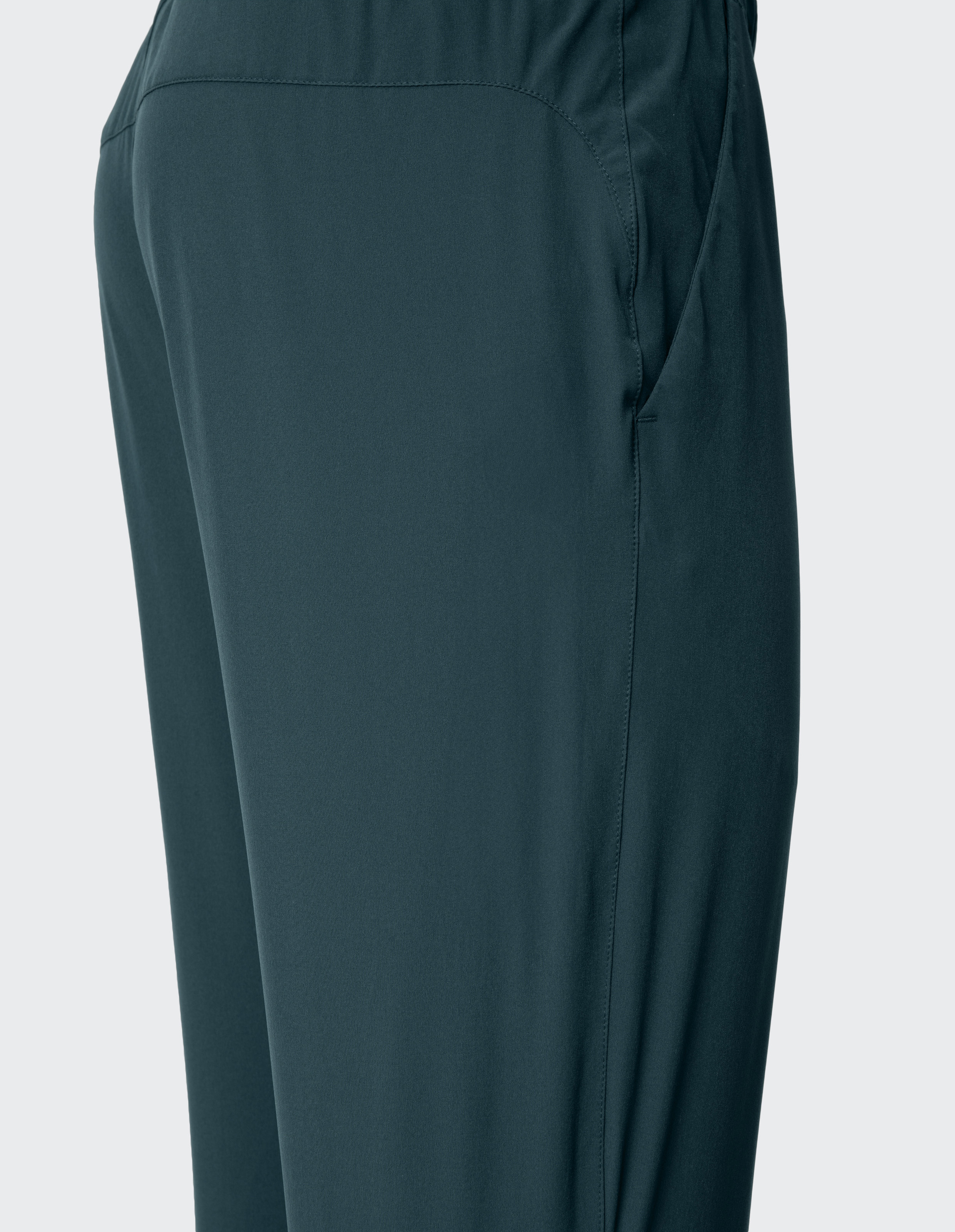 Dunkelgrüne Hose mit elastischem Bund und seitlicher Nahttasche, aus weichem Stoff, fokussiert auf die Hüftpartie und Seitendetail.