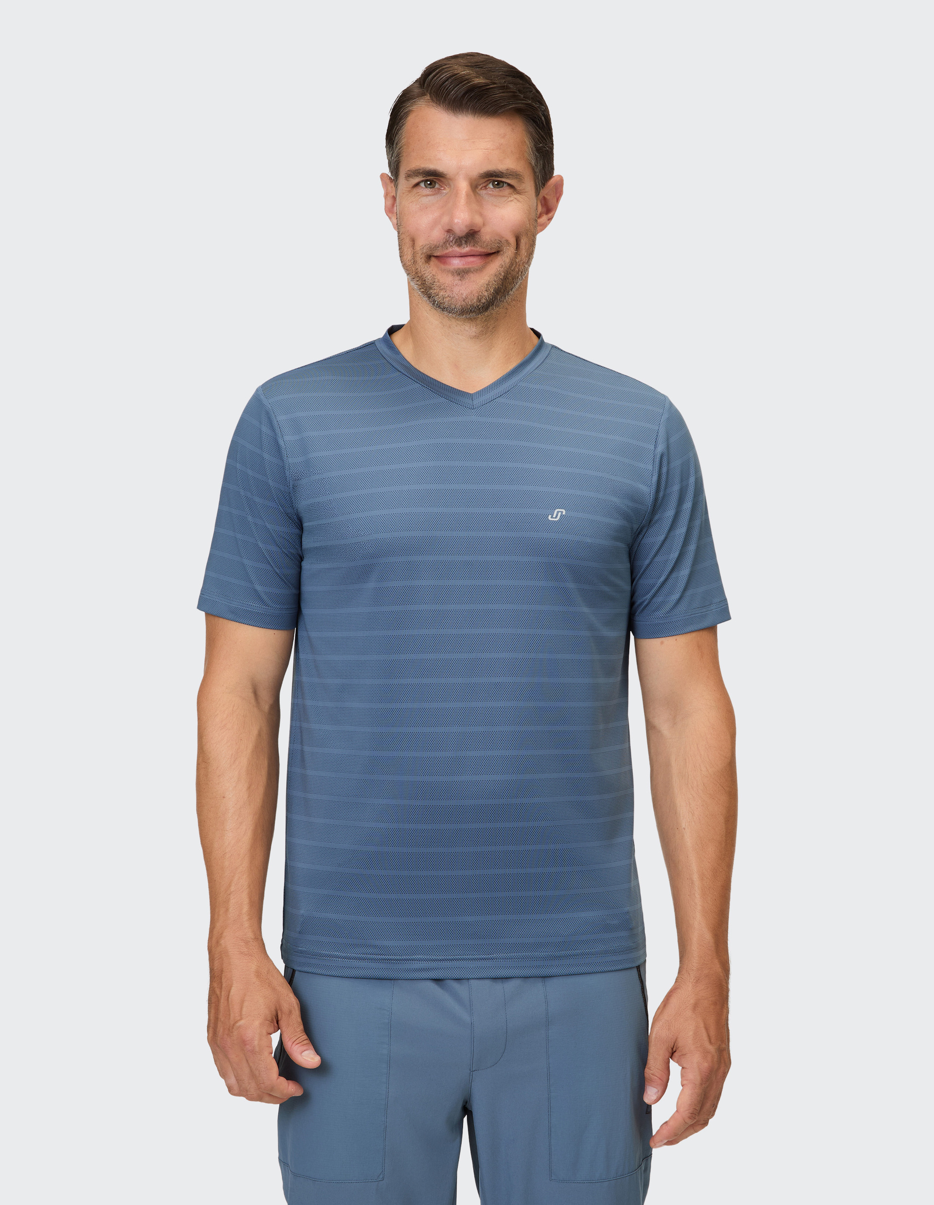 Ein Mann trägt ein blaues V-Ausschnitt-Shirt mit horizontalen Streifen und ein passendes blaues Hemd.