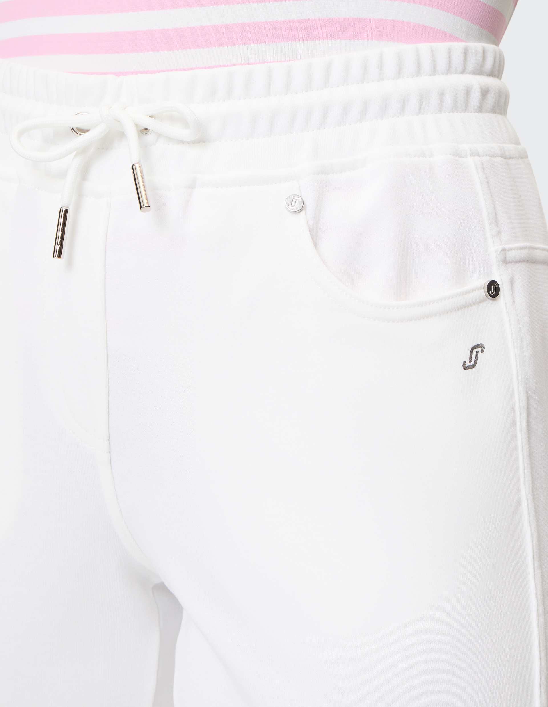 Weiße Jogginghose mit elastischem Bund und Kordelzug, dazu ein Oberteil mit rosa und weißen Streifen, Nahaufnahme der Vorderseite.